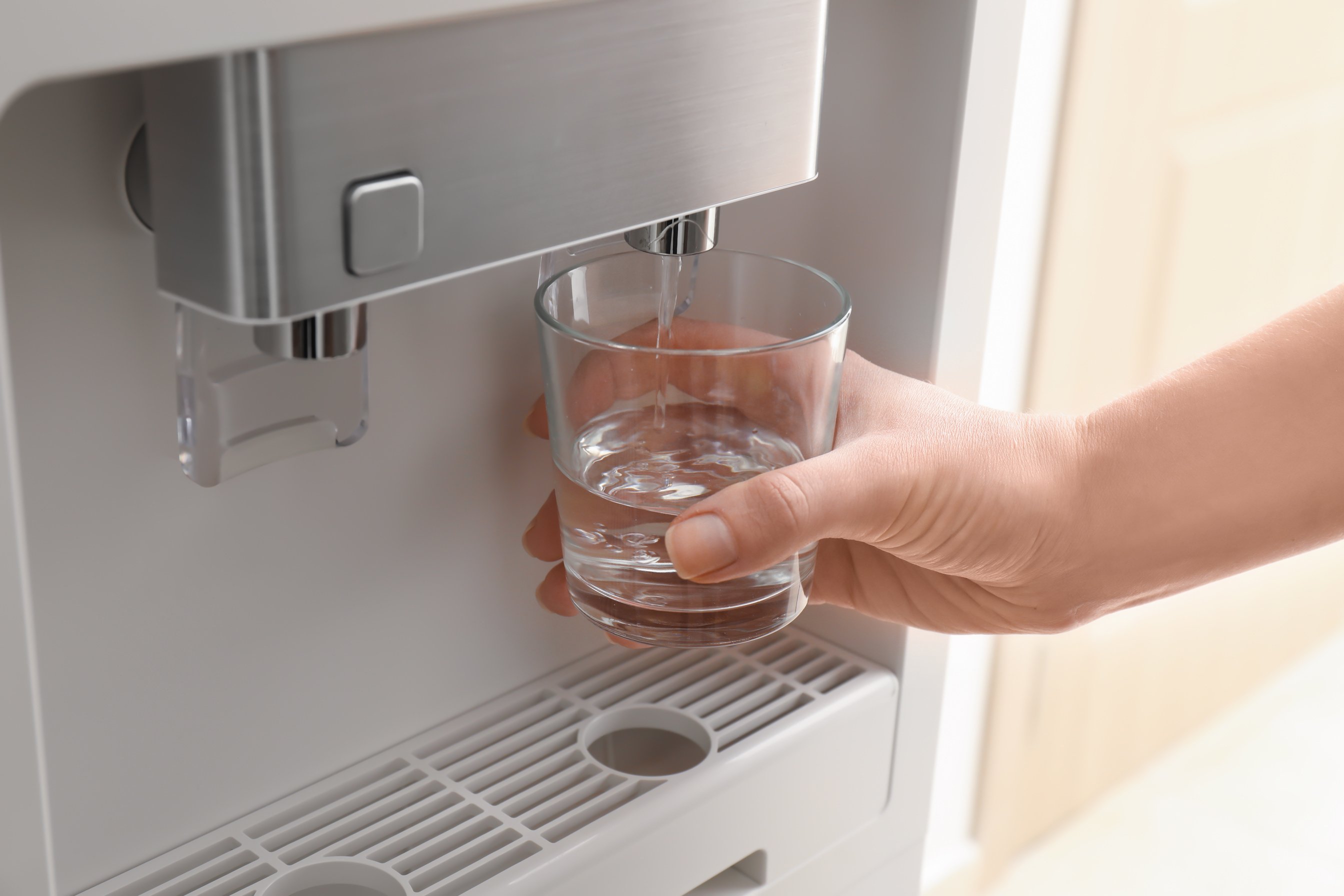 Woman Filling Glass from Water Cooler